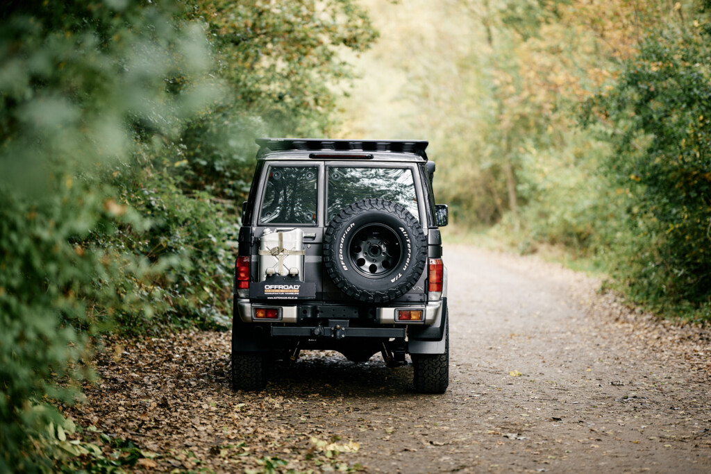 Toyota Land Cruiser GRJ76 von hinten mit Reserverad auf Waldweg