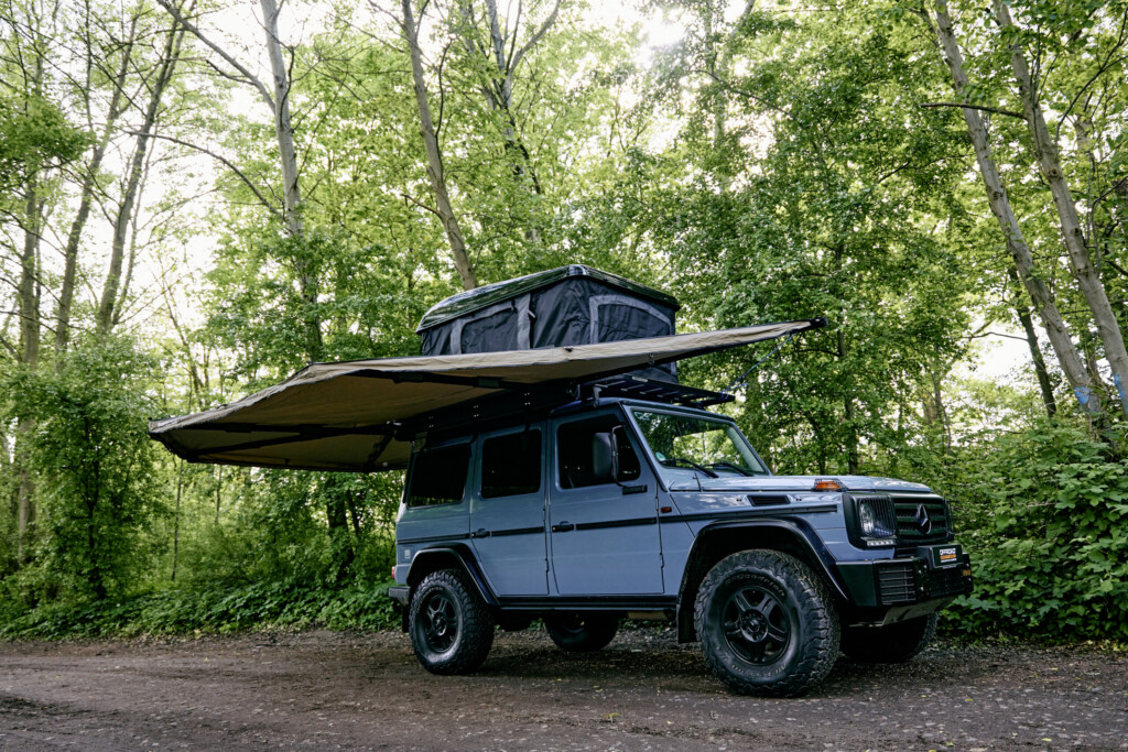 Mercedes G-Klasse mit aufgespannter 270-Grad-Markise und Dachzelt im Wald
