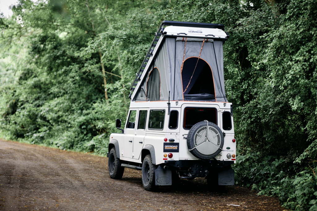 Land Rover Defender 110 mit geöffnetem Icarus Hubdach, Heckansicht