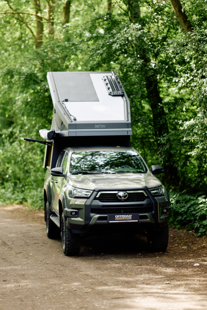 Toyota Hilux mit aufgestellter FiftyTen Wohnkabine im Wald