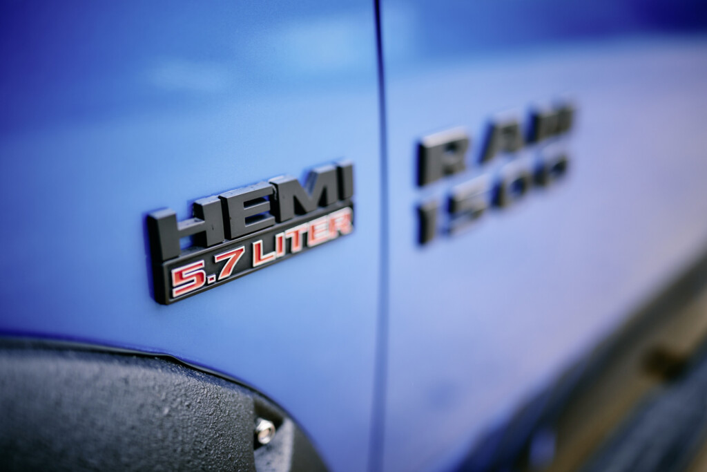 Nahaufnahme der HEMI 5.7 Liter und RAM 1500 Embleme am blauen Dodge RAM 1500