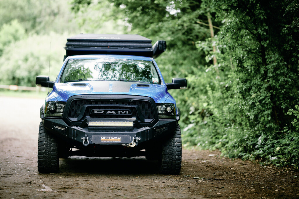 Frontansicht des blauen Dodge RAM 1500 mit RAM-Grill, LED-Lightbar und OFFROAD Manufaktur Frontstoßstange