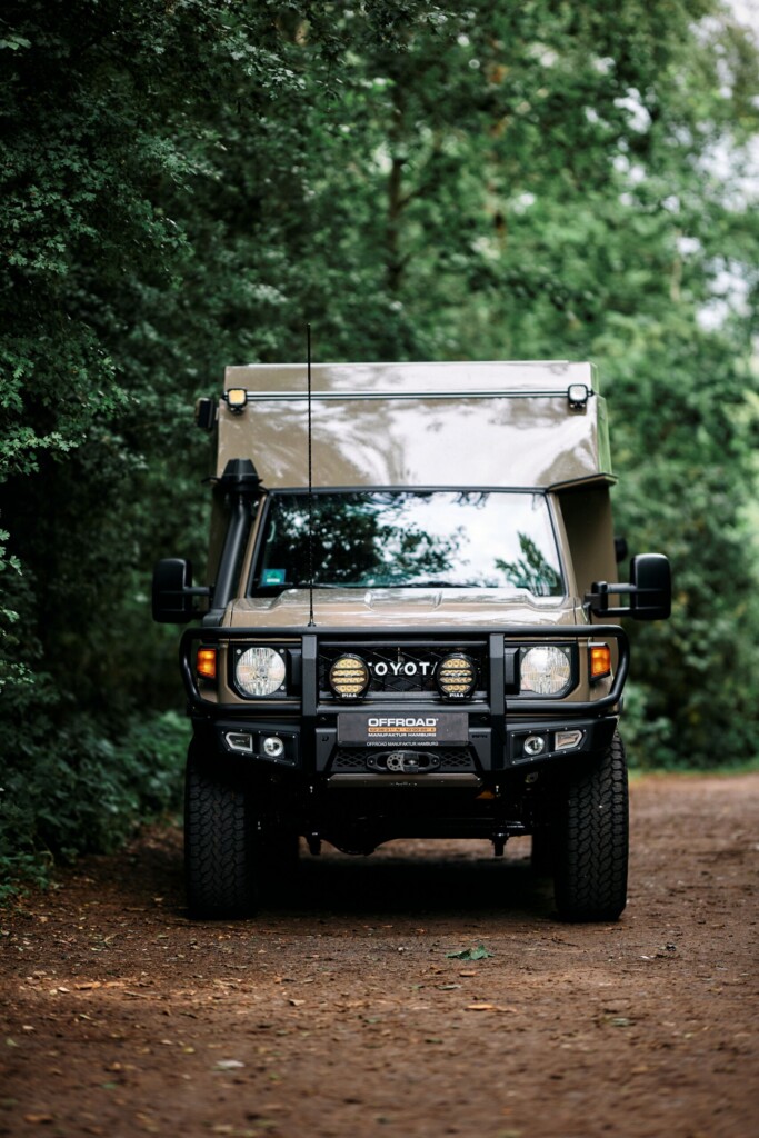 Toyota Land Cruiser J7 expedition camper with camper cell, front view on a forest track