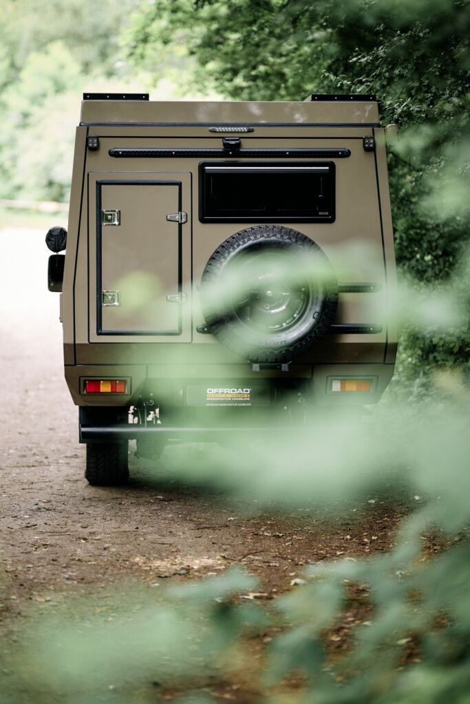 Heckansicht des Land Cruiser J7 mit Camper-Aufbau, Reserverad und Stauklappen