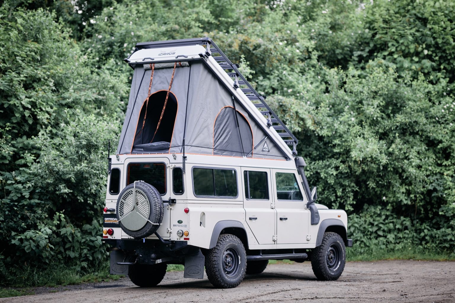 Land Rover Defender 110 mit aufgestelltem Alu-Cab Icarus Hubdach, schräg von hinten