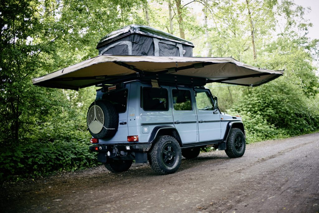 Mercedes G-Klasse mit ausgeklappter Rhino-Rack Batwing Markise und Dachzelt, schräg von hinten