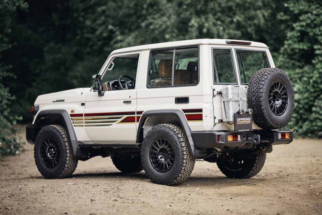 Toyota Land Cruiser GRJ71 in Weiß mit Retro-Streifen, schräg von hinten