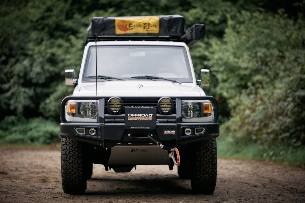 Toyota Land Cruiser GRJ71 70th Anniversary von vorne mit AFN Windenstoßstange, PIAA Zusatzscheinwerfern und Dachzelt