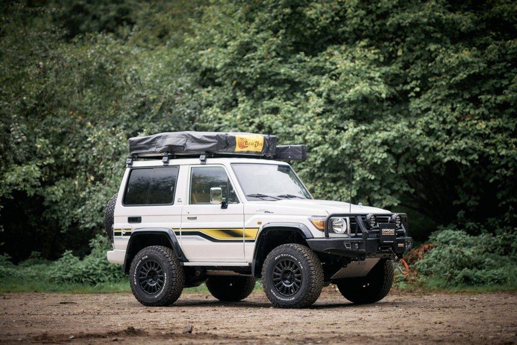 Toyota Land Cruiser GRJ71 70th Anniversary von der Seite mit Dachzelt im Wald