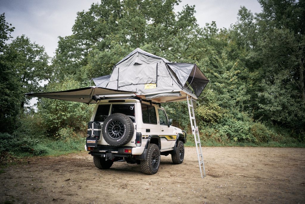 Land Cruiser GRJ71 im Camp mit Dachzelt, Markise und Reserverad an der Hecktür