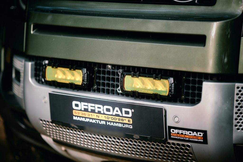 Zwei Lazer Triple-R 750 Elite mit gelben Vorsatzlinsen im Kühlergrill des New Defender