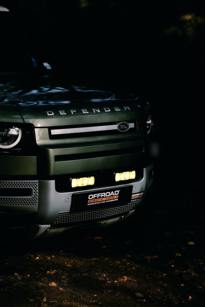 Front des New Defender mit leuchtenden Lazer-Scheinwerfern im Grill