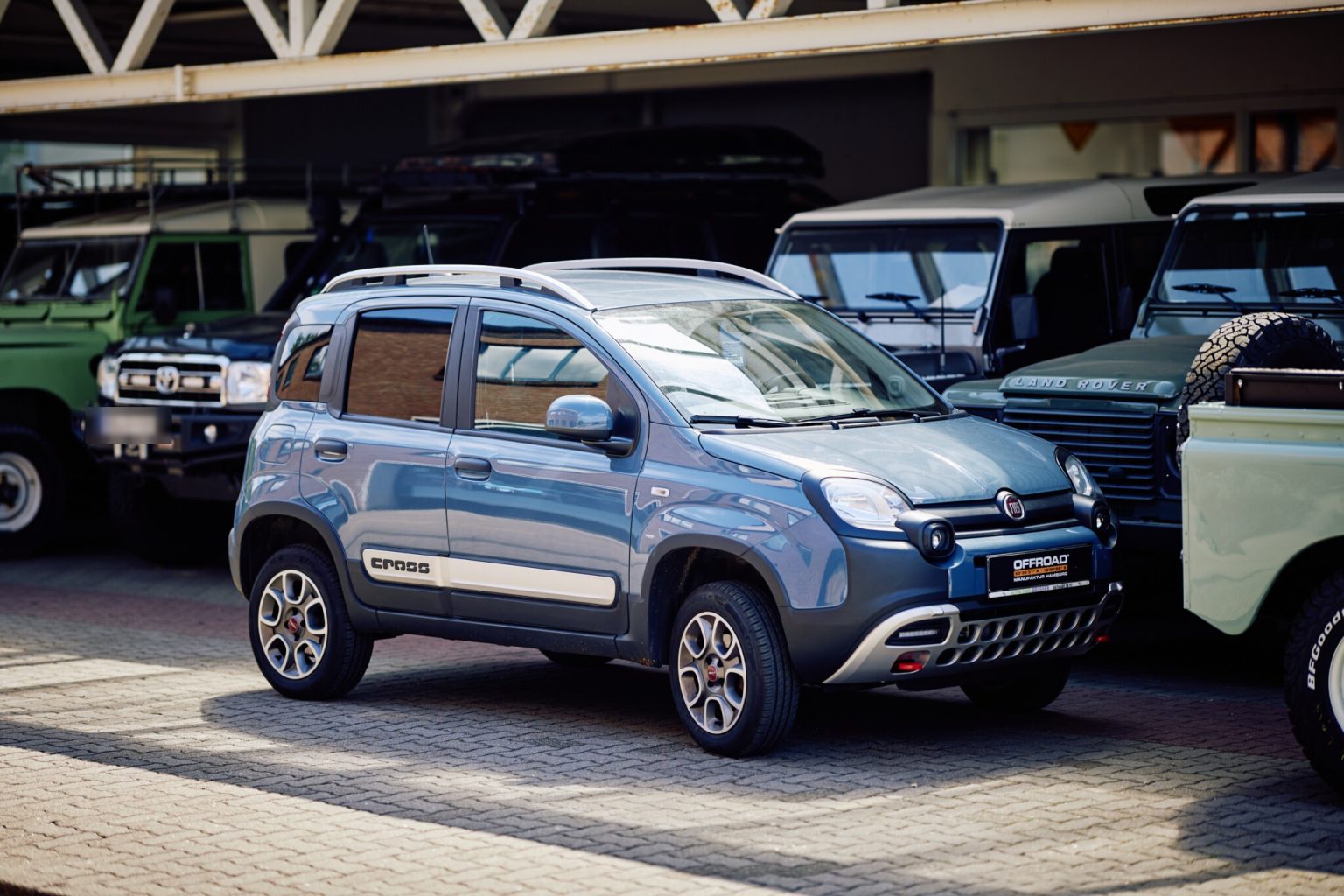 Fiat Panda 4x4 zwischen Land Cruiser und Defender auf dem Hof